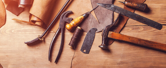 Leather craft workshop. Shoemaker's work desk. Tools and leather at cobbler workplace.