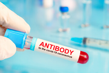 A test tube with blood in the doctor's hand. COVID-19 antibody test, blood sample tube for COVID-19...