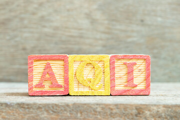 Color alphabet letter block in word AQI (Abbreviation of air quality index) on wood background
