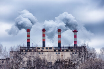 Factory chimneys from which there is dense gray smoke 