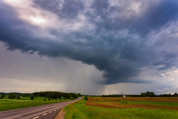 Extreme thunderstorm shelf cloud moving over fields, climate change concept