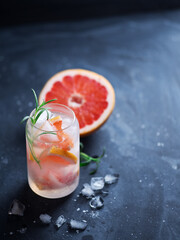 Stylish summer ice alcoholic cocktail with grapefruit and rosemary. Gin and tonic