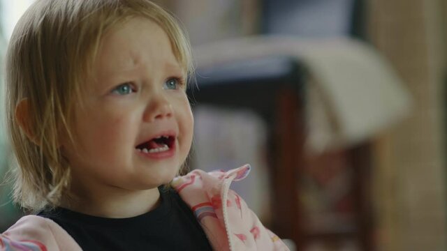 Close up portrait of hardly crying caucasian little girl. tears streaming down her face. Real human emotions. Children face wet from tears. 4k. Moody toddler girl