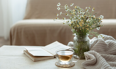 Cozy home composition with a cup of tea, a book and flowers copy space. - Powered by Adobe