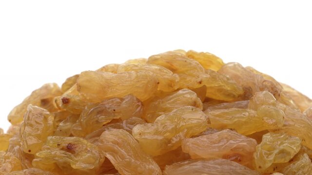 Macro shot of golden sultana raisins isolated on white background.