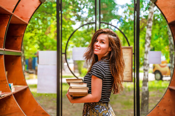 A beautiful young woman in the library holds books. Togliatti, Russia - 29 May 2021
