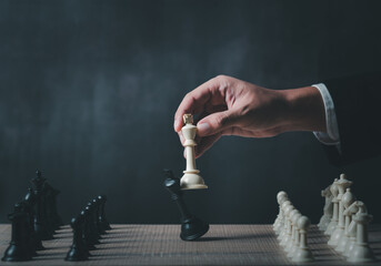 hand of businessman wearing suit moving chess figure in competition success play....