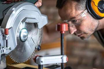 Professional carpenter working with a miter saw.