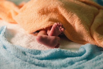 Tiny feet and cute toes of a newborn baby. On the cloth shows the love, warm, pure and bright of the family.

