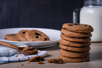 cookie chocolate chip breakfast snack bakery dessert with milk. sweet breakfast in the mornong ,unhealthy food on wooden table and dark black background.