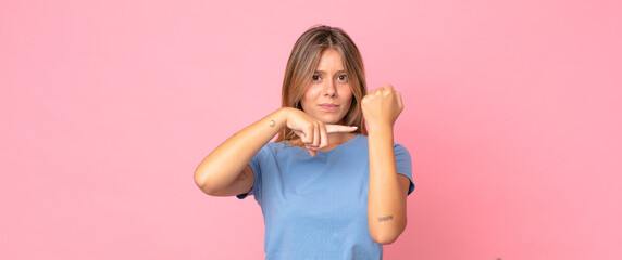 blonde pretty woman looking impatient and angry, pointing at watch, asking for punctuality, wants...