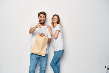 young couple in white t-shirts paper bag sale shopping