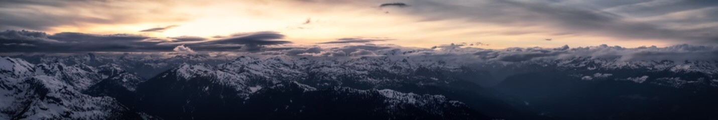 Aerial Panoramic View from Airplane of Canadian Mountain Landscape in Spring time. Colorful Sunset. North of Vancouver, British Columbia, Canada. Nature Panorama, Dark Moody Art Render