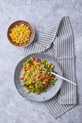 Quinoa salad with green beans, corn, red bell peppers, peas and soybeans. Useful vegetable mix