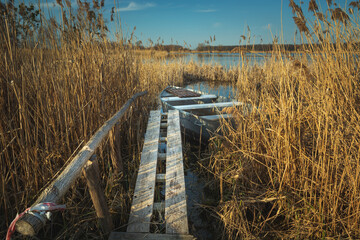 A wooden footbridge in the reeds and a fishing boat