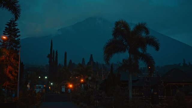 street at night in the dark with clouds and blue skies in the background covering the volcano