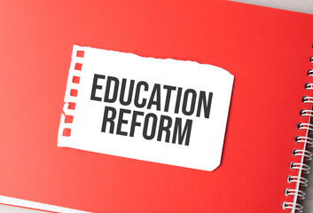 The word Education Reform on torn paper on red notepad,.
