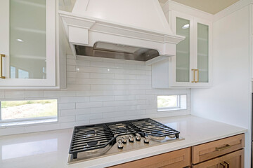 White kitchen counter with built-in gas cooktop with griddle in stainless steel