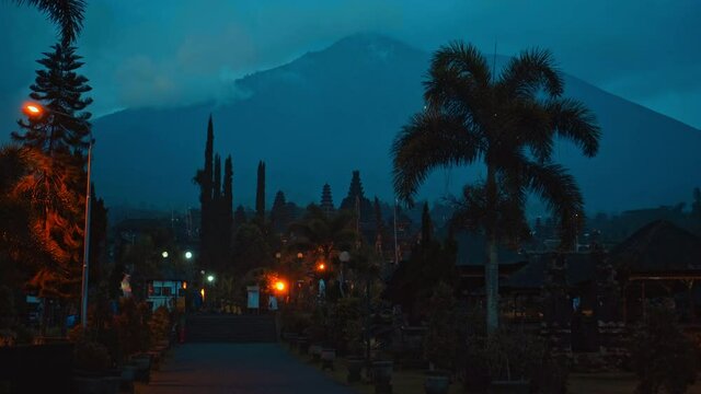 street at night in the dark with clouds and blue skies in the background covering the volcano