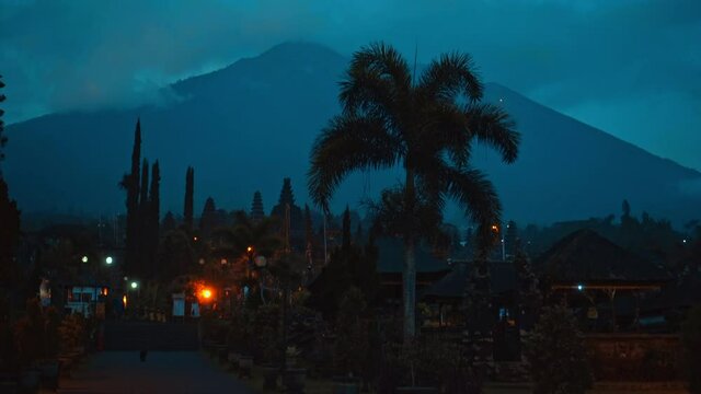 street at night in the dark with clouds and blue skies in the background covering the volcano