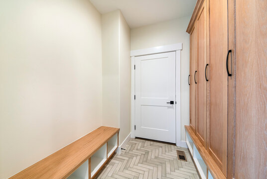 Mudroom Interior With Herringbone Tile Pattern Flooring And Wooden Cabinet