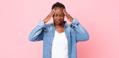 afro black adult woman looking stressed and frustrated, working under pressure with a headache and...