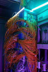 Futuristic background image of server cabinet with cables and wires in purple light