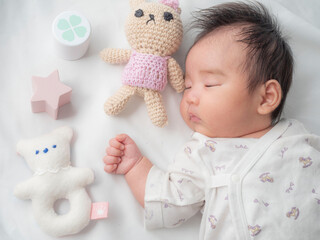 お気に入りのおもちゃと寝る赤ちゃん