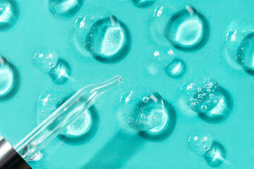 Pipette with drops of different forms of hyaluronic acid on a glass stand, blue background. Cosmetics concept.