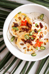 spicy lotus root salad on the white stone background, asian food 