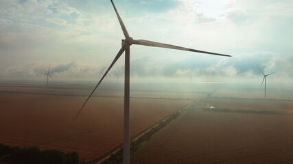 Fototapeta premium Eco Energy Concept with Wind Turbine Close-up in Low Cloudy