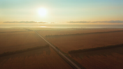 Beautiful landscape aerial photography of sunrise over wheat fields in foggy morning
