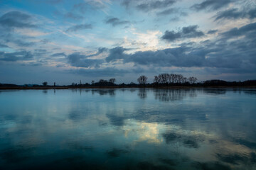 Reflection of evening clouds in a frozen lake