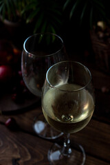 White wine is poured into glasses. There are fruits nearby