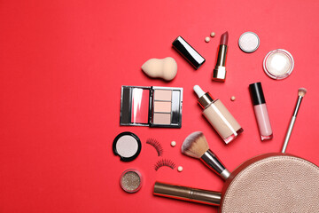 Different makeup products with cosmetic bag on red background, flat lay. Space for text