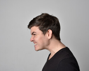 Close up head and shoulders portrait of a brunette. young man with a variety of expressive facial expressions. Isolated on a light grey studio background.