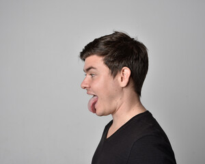 Fototapeta premium Close up head and shoulders portrait of a brunette. young man with a variety of expressive facial expressions. Isolated on a light grey studio background.