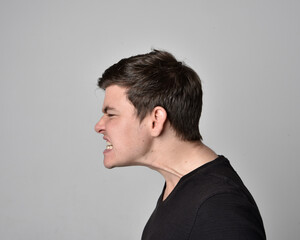 Obraz premium Close up head and shoulders portrait of a brunette. young man with a variety of expressive facial expressions. Isolated on a light grey studio background.