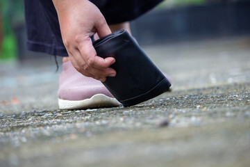 a woman picks up a dropped wallet