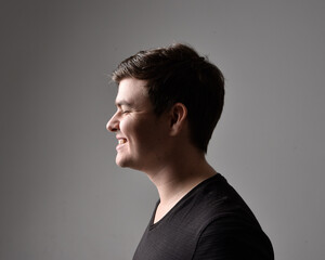 Obraz premium Close up head and shoulders portrait of a brunette. young man with a variety of expressive facial expressions. Isolated on a light grey studio background.