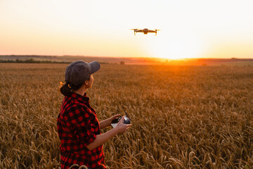 Woman farmer with drone on a wheat field. Smart farming and precision agriculture