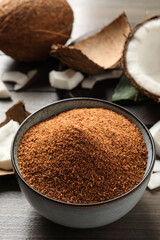 Natural coconut sugar in ceramic bowl on wooden table