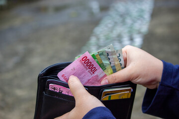 a woman takes out rupiah from her purse