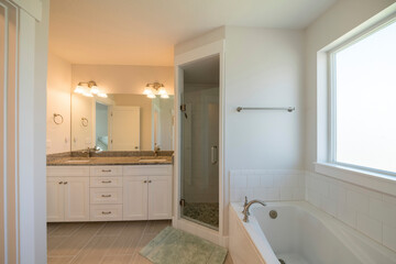 Master bathroom with corner shower stall and window