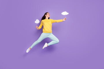 Fototapeta na wymiar Full body photo of dreamy young cool happy woman jump up look empty space hold clouds isolated on violet color background