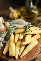 Fresh baby corn cobs on wooden board, closeup