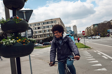 Male courier with bicycle delivering packages in city.