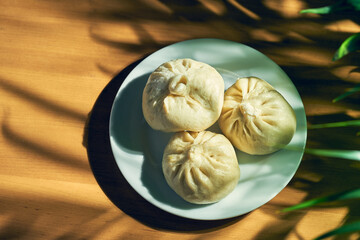 Baozi with different fillings (beef or pork) in a white plate. Chinese recipe and cuisine. Chinese steamed meat bun