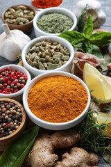 Different natural spices and herbs on table, closeup