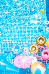 various inflatable on a pool water background. ball, crab, dolphin, float. summer and travel concept. copy space